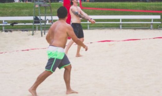men playing beach volleyball at fitness center