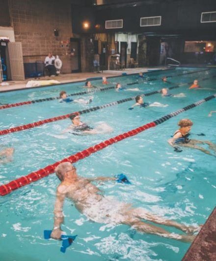 gym members in spacious pool doing water aerobics