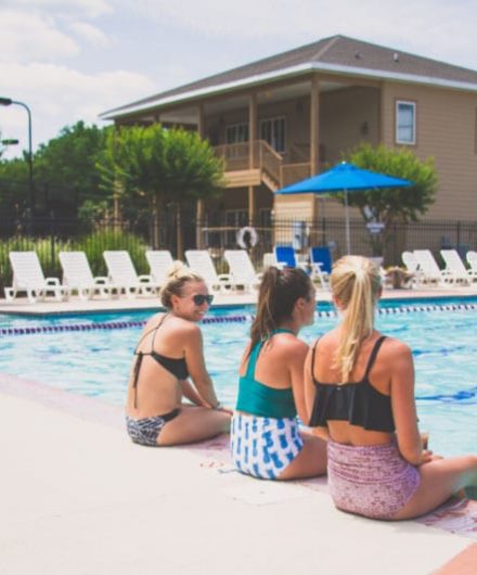 women sitting at large outdoor pool