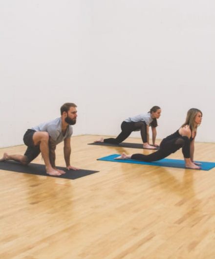 yoga class members posing in spacious studio